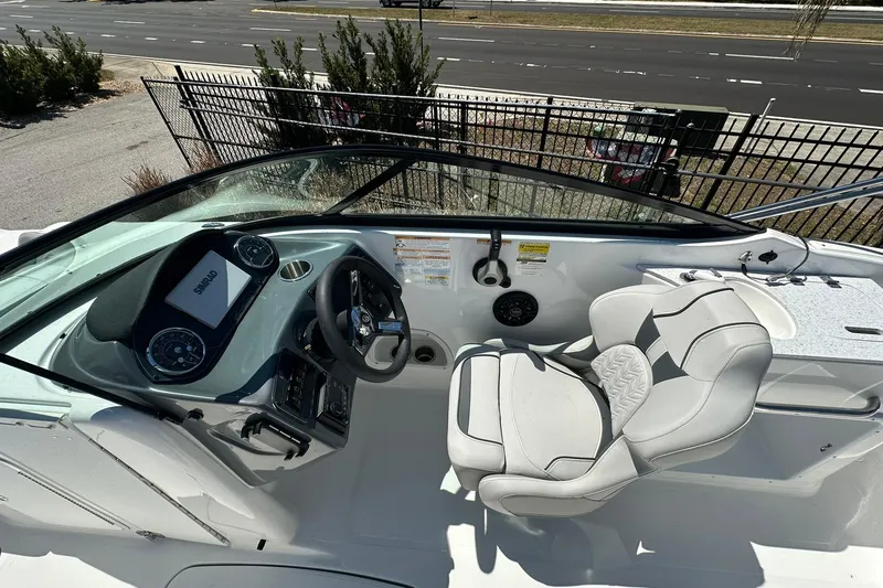 Slide: The Image of 2026 Hurricane SunDeck 2400 OB boat cockpit with steering wheel and seating. - 15