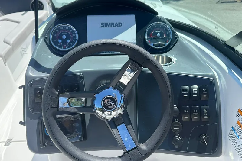 Slide: The Image of Steering console of 2026 Hurricane SunDeck 2400 OB with Simrad display and controls. - 16