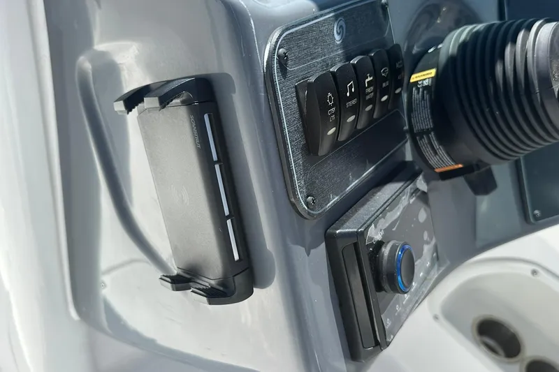 Slide: The Image of Control panel of 2026 Hurricane SunDeck 2400 OB boat with switches and steering wheel. - 20