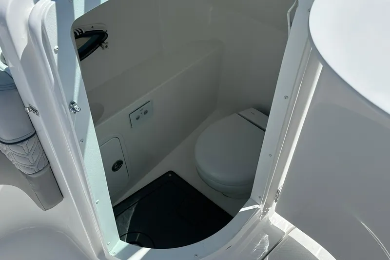 Slide: The Image of 2026 Hurricane SunDeck 2400 OB boat interior with compact marine toilet. - 27