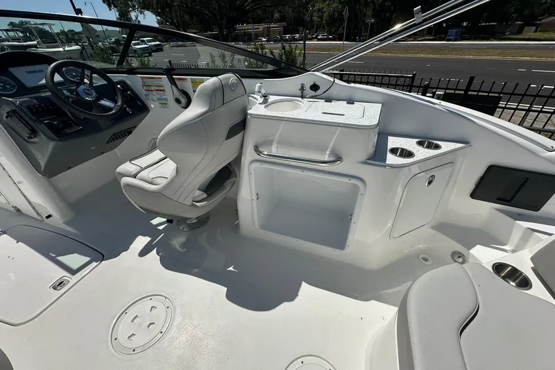 Slide: The Image of 2026 Hurricane SunDeck 2400 OB boat interior with helm, seating, and sink area. - 29