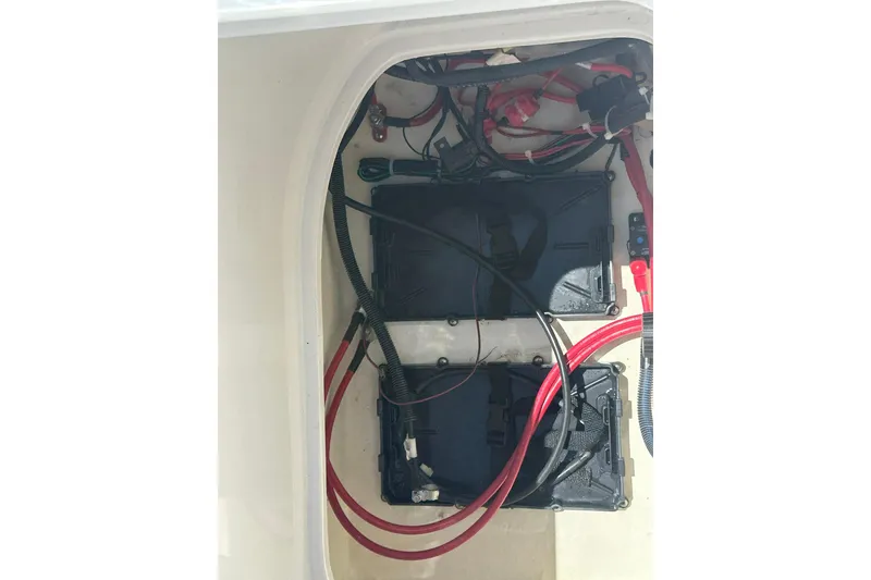 Slide: The Image of Battery compartment of a 2026 Hurricane SunDeck 2400 OB boat with wiring and connections. - 39