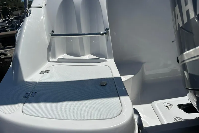 Slide: The Image of 2026 Hurricane SunDeck 2400 OB boat interior with seating and engine detail. - 41