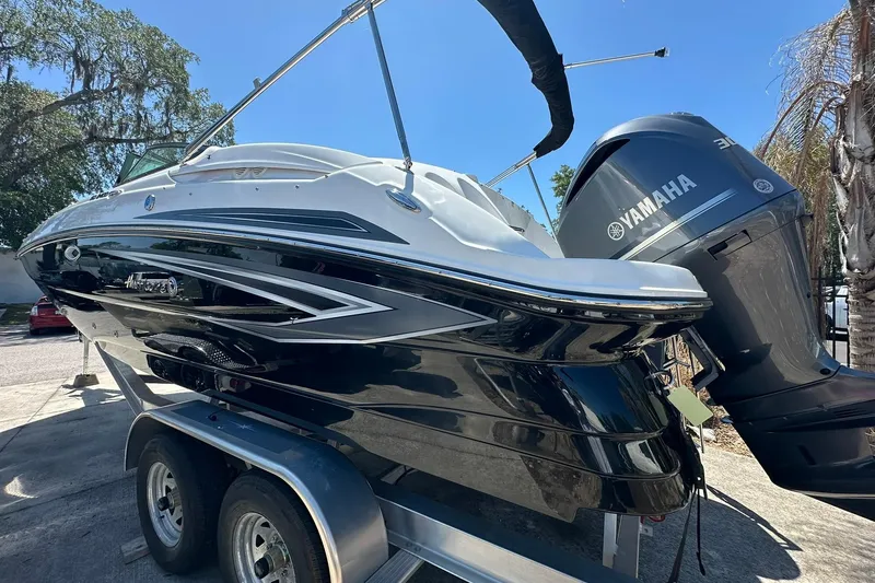 Slide: The Image of 2026 Hurricane SunDeck 2400 OB boat with Yamaha engine on trailer, parked outdoors. - 43