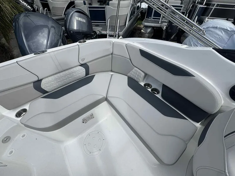 Slide: The Image of 2025 Hurricane SunDeck 2400 OB boat interior with cushioned seating and cup holders. - 6