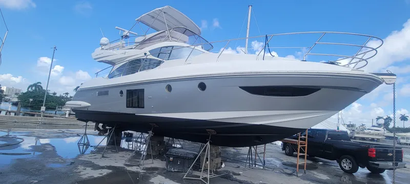 Slide: The Image of 2013 Azimut 45 Flybridge yacht on dry dock under clear blue sky. - 1