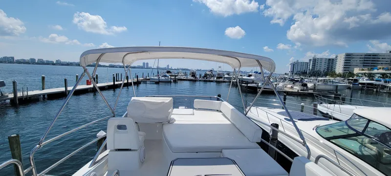 Slide: The Image of 2013 Azimut 45 Flybridge yacht docked at a marina with a scenic waterfront view. - 18