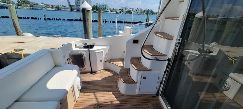 Slide: The Image of Azimut 45 Flybridge 2013 yacht deck with seating and stairs, docked at marina. - 6