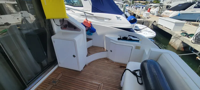 Slide: The Image of 2013 Azimut 45 Flybridge yacht deck with wooden flooring and storage compartments. - 9