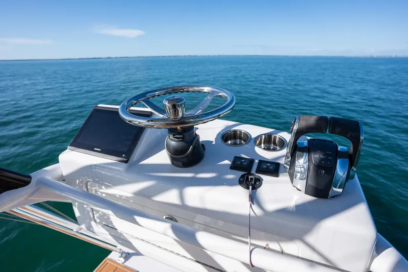 Slide: The Image of Freeman 47 boat helm with steering wheel and controls, 2022 model, on open water. - 35