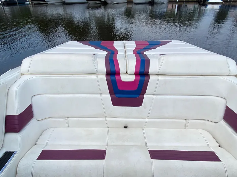 Slide: The Image of 1998 Fountain 35 Lightning boat with white and purple seating, docked on calm water. - 8