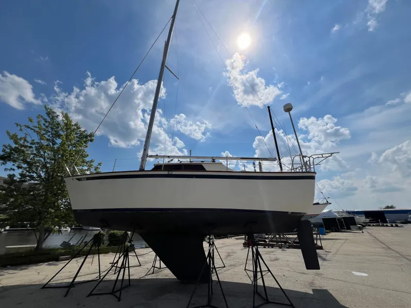 The Image of 1982 Campion C-320 Pilot House sailboat on stands under a sunny sky. - 0