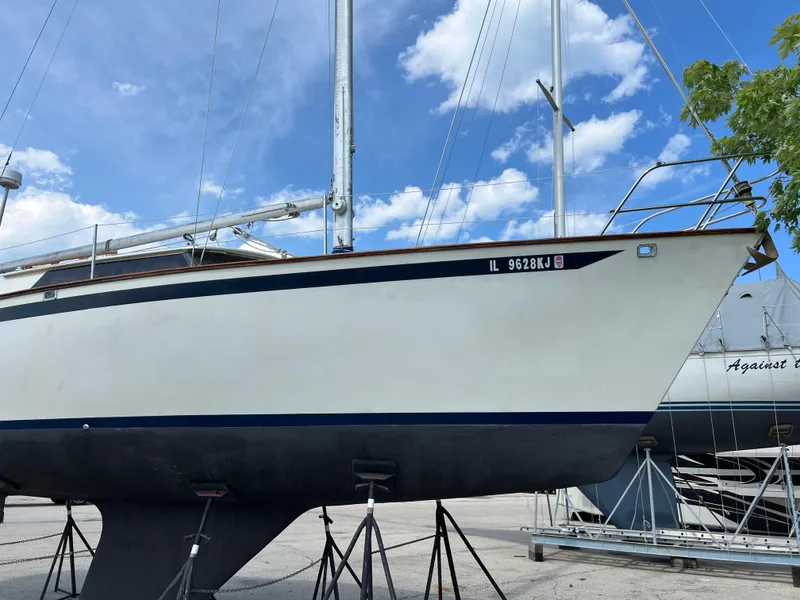 Slide: The Image of 1982 Campion C-320 Pilot House sailboat on stands under a blue sky. - 2