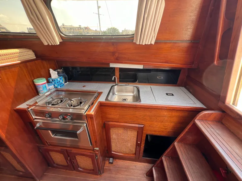 Slide: The Image of 1982 Campion C-320 Pilot House kitchen with stove, sink, and wooden cabinetry. - 24
