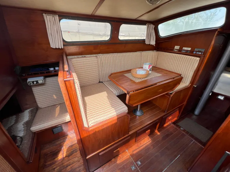 Slide: The Image of 1982 Campion C-320 Pilot House interior with wooden dining area and cushioned seating. - 27