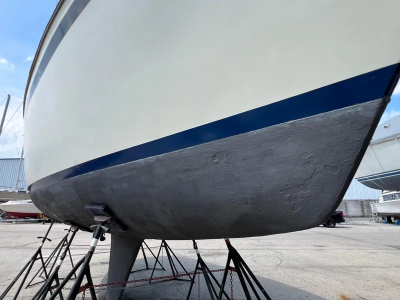 Slide: The Image of 1982 Campion C-320 Pilot House boat hull on stands in a marina. - 3