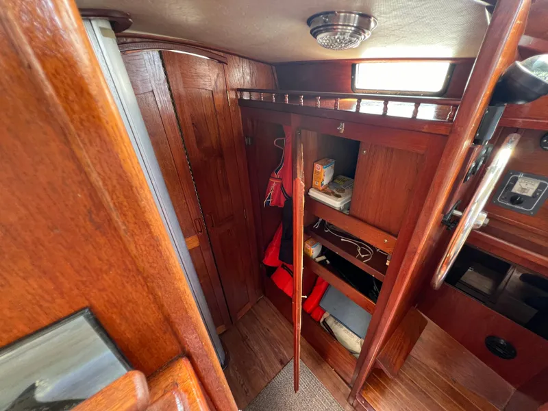 Slide: The Image of 1982 Campion C-320 Pilot House interior with wooden cabinets and storage shelves. - 39