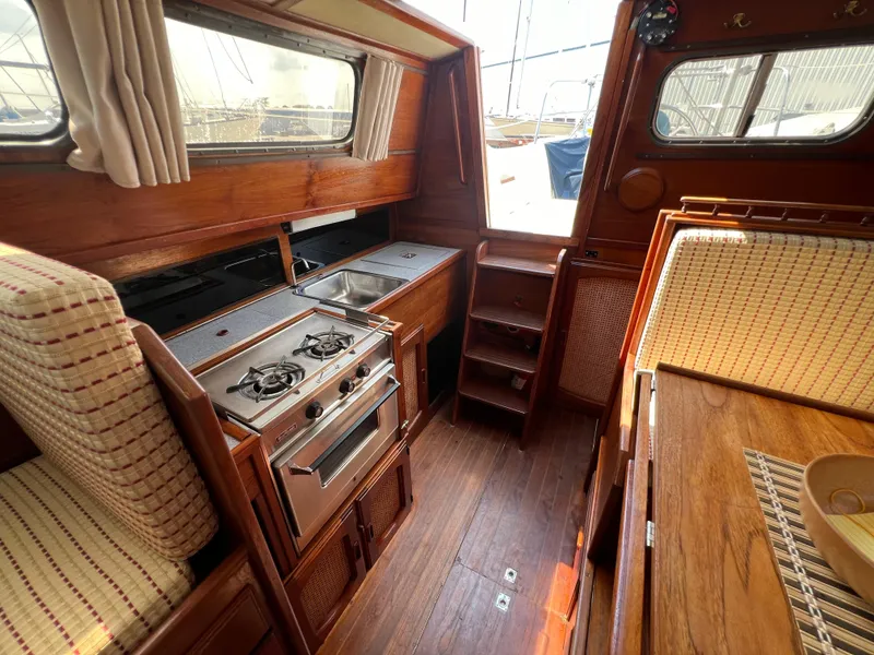 Slide: The Image of 1982 Campion C-320 Pilot House interior with wooden cabinetry, stove, and seating. - 47