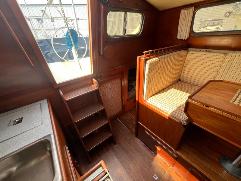 Slide: The Image of Interior of 1982 Campion C-320 Pilot House with wooden stairs, seating, and kitchenette. - 48