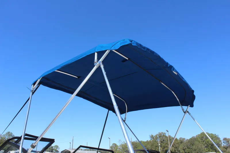 Slide: The Image of 2018 Glastron GT200 boat with blue bimini top against clear sky. - 27