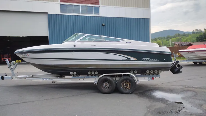 The Image of 1996 Chaparral 2330 SS boat on a trailer outside a warehouse. - 1