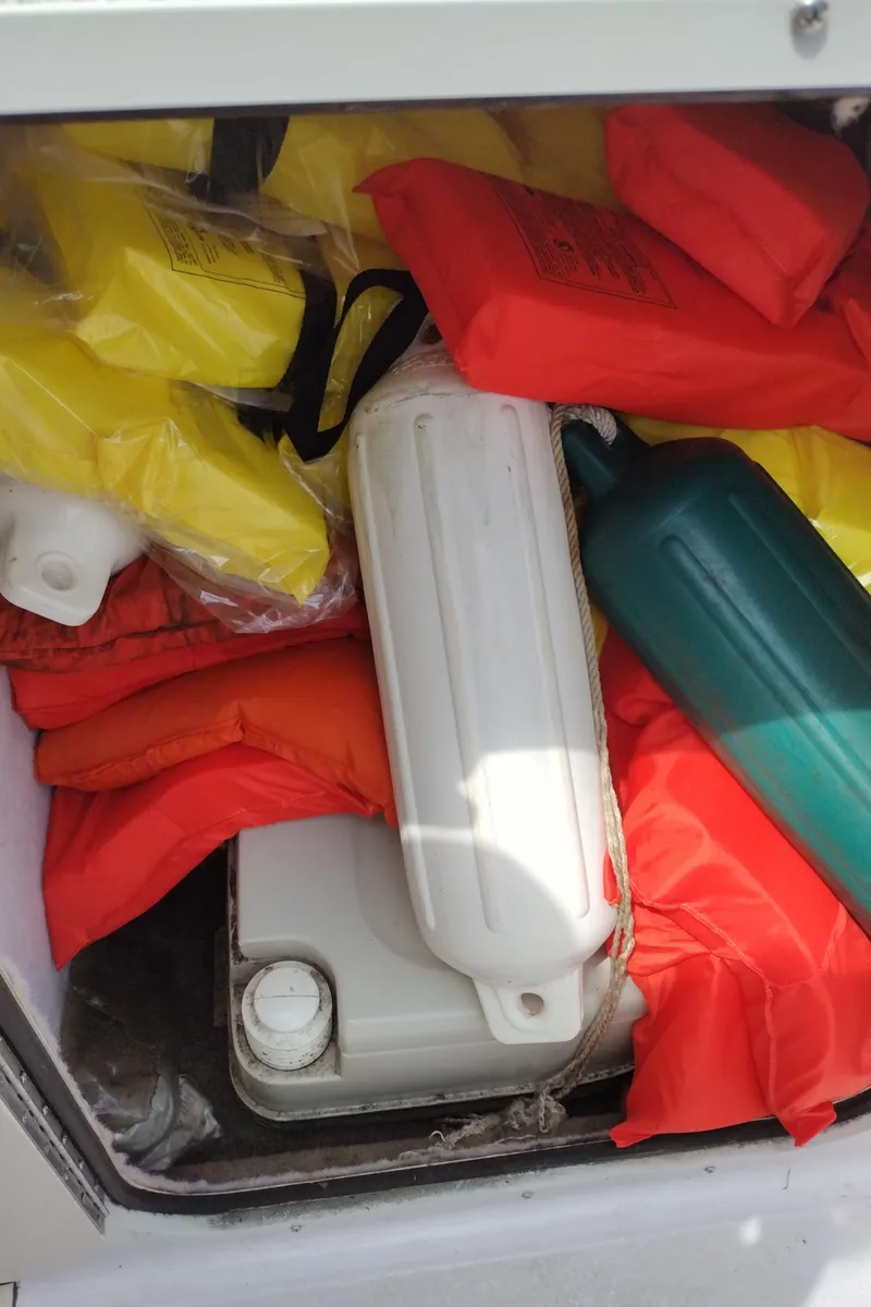 Slide: The Image of Storage compartment of a 1996 Chaparral 2330 SS boat with life jackets and fenders. - 21