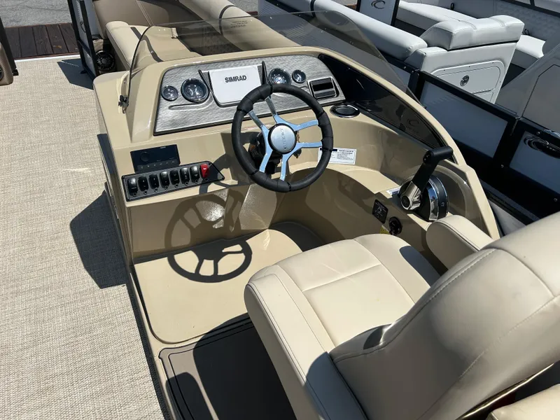Slide: The Image of 2024 Crest Classic Platinum 240 SLC boat interior with steering wheel and control panel. - 14