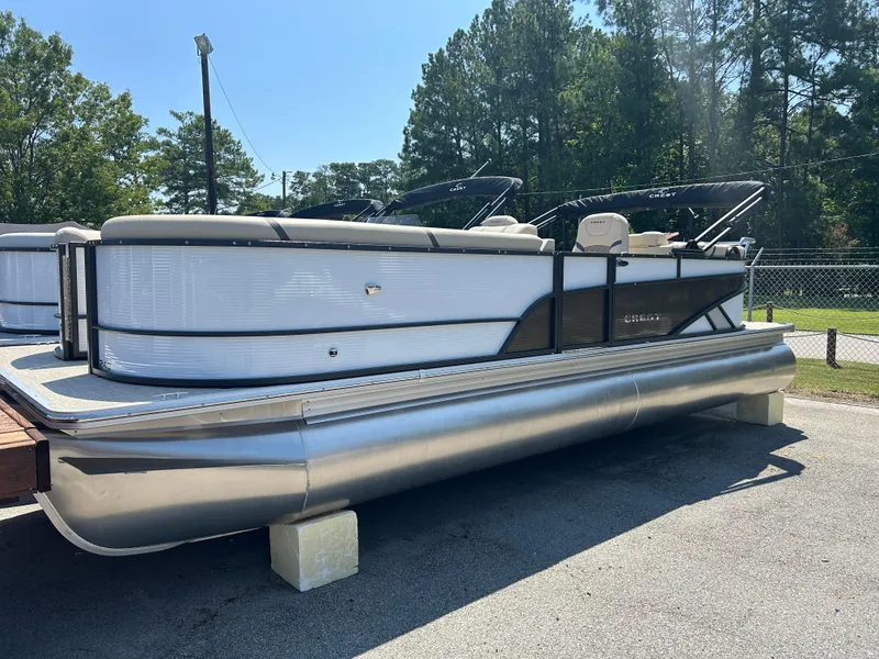 The Image of 2024 Crest Classic Platinum 240 SLC pontoon boat on display outdoors. - 6
