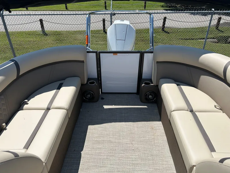 Slide: The Image of 2024 Crest Classic Platinum 240 SLC boat interior with beige seating and carpet flooring. - 8