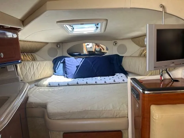 Slide: The Image of 2007 Sea Ray 290 Amberjack cabin interior with bed, TV, and skylight. - 2