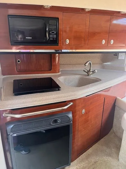 Slide: The Image of 2007 Sea Ray 290 Amberjack galley with microwave, sink, and stove. - 3