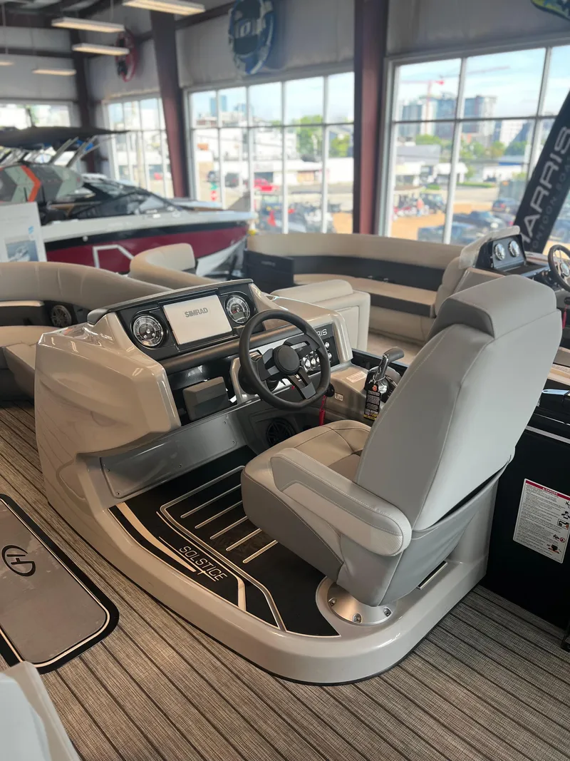 Slide: The Image of 2024 Harris Solstice 230 boat interior with captain's chair and dashboard. - 19