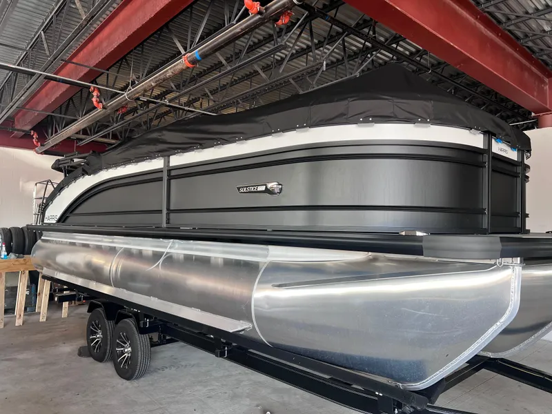 Slide: The Image of 2024 Harris Solstice 230 pontoon boat in a showroom. - 2