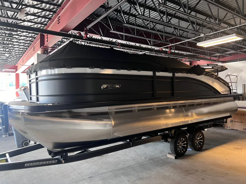 Slide: The Image of 2024 Harris Solstice 230 pontoon boat on a trailer in a covered storage area. - 7