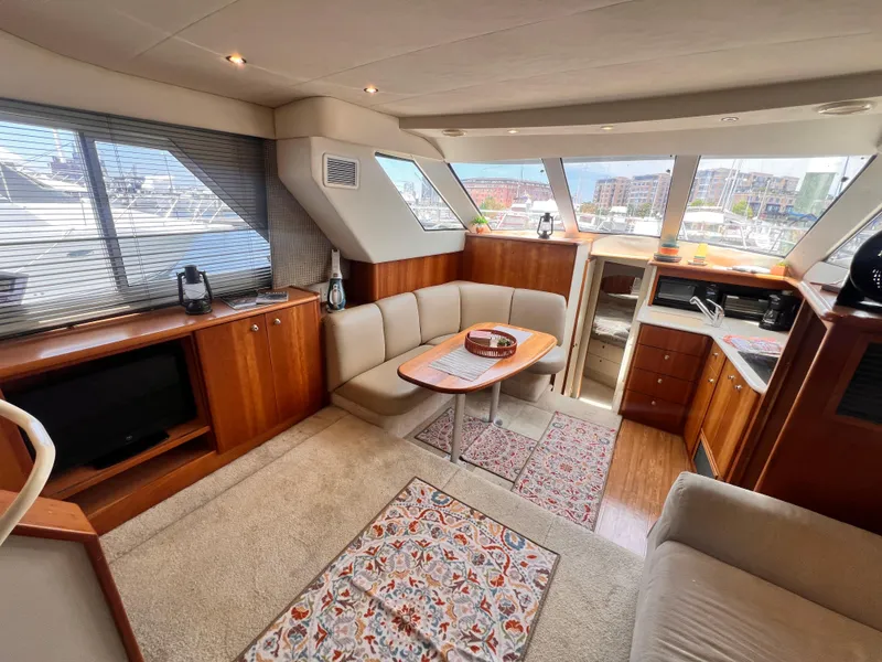 Slide: The Image of Interior of a 2001 Silverton 352 Motor Yacht with cozy seating and wooden cabinetry. - 12