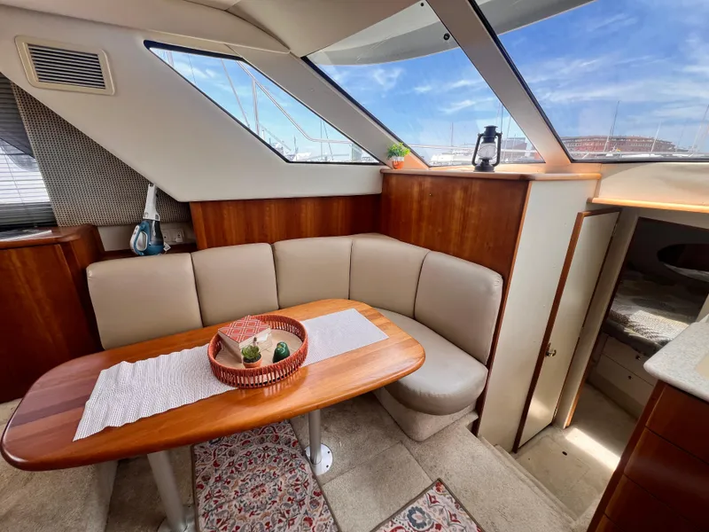 Slide: The Image of Interior of 2001 Silverton 352 Motor Yacht with dining area and panoramic windows. - 14