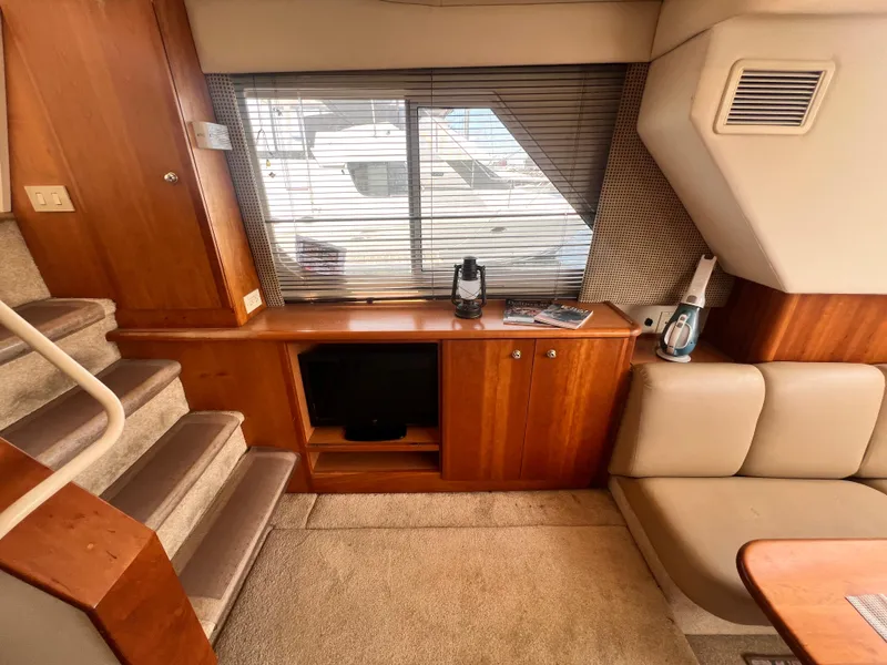 Slide: The Image of Interior of 2001 Silverton 352 Motor Yacht with wooden cabinetry, stairs, and seating area. - 16