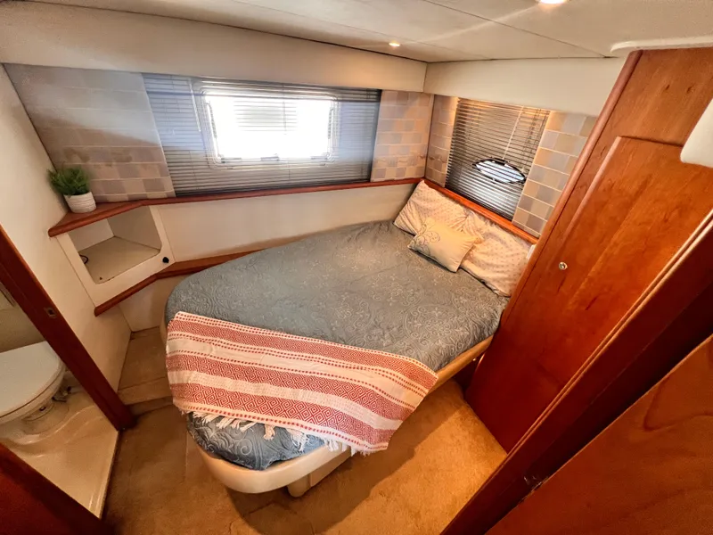 Slide: The Image of Cozy bedroom in 2001 Silverton 352 Motor Yacht with bed, window, and wooden cabinetry. - 17