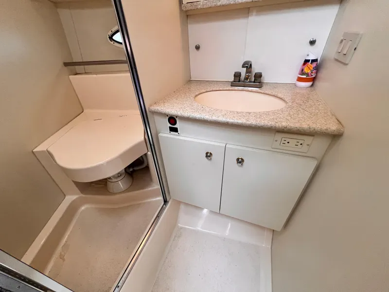 Slide: The Image of 2001 Silverton 352 Motor Yacht bathroom with sink, toilet, and storage cabinets. - 18