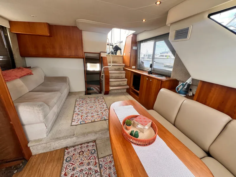 Slide: The Image of Interior of a 2001 Silverton 352 Motor Yacht with cozy seating and wooden accents. - 9