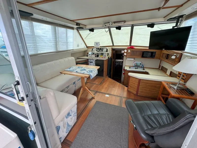 Slide: The Image of Interior of 1985 Sea Ray 390 Sedan Bridge yacht with helm, seating, and TV. - 11
