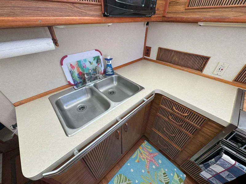 Slide: The Image of 1985 Sea Ray 390 Sedan Bridge kitchen with double sink and countertop. - 20