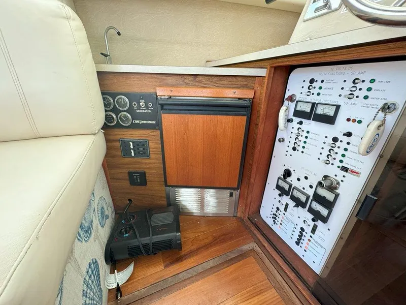 Slide: The Image of 1985 Sea Ray 390 Sedan Bridge control panel and mini fridge. - 24