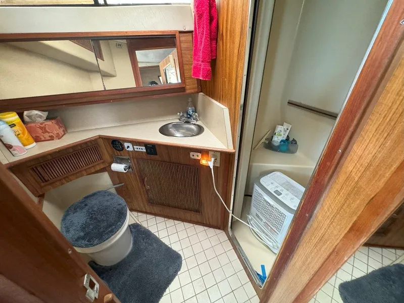 Slide: The Image of 1985 Sea Ray 390 Sedan Bridge bathroom with sink, toilet, and shower. - 29
