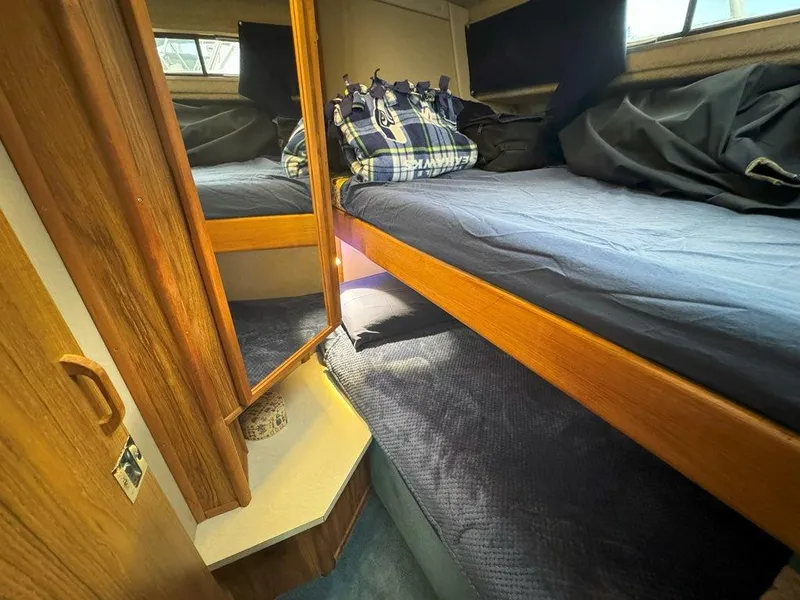 Slide: The Image of Interior cabin of 1985 Sea Ray 390 Sedan Bridge with bunk beds and plaid bag. - 33