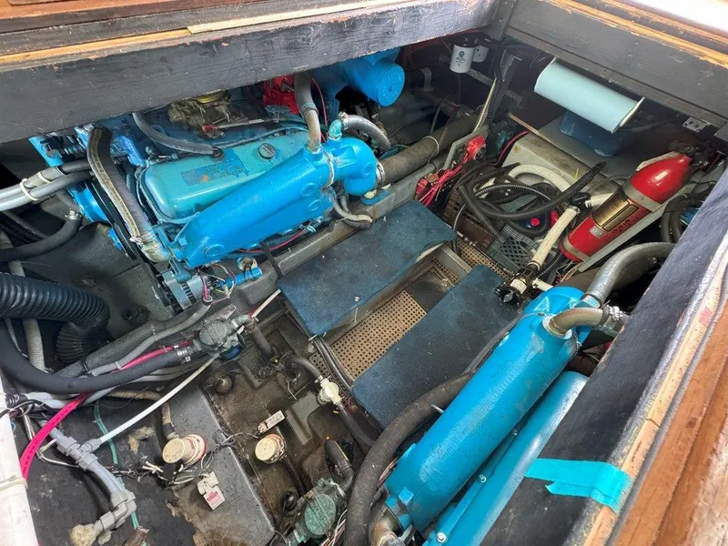 Slide: The Image of Engine room of a 1985 Sea Ray 390 Sedan Bridge with blue engines and fire extinguisher. - 35