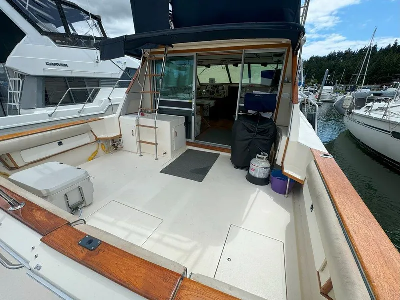 Slide: The Image of 1985 Sea Ray 390 Sedan Bridge yacht docked at marina, spacious deck area. - 4