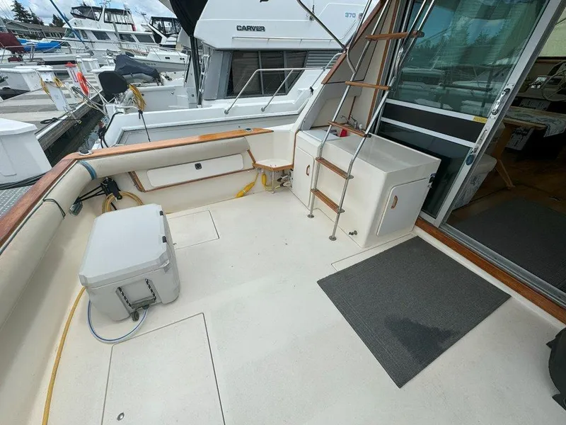 Slide: The Image of 1985 Sea Ray 390 Sedan Bridge boat deck with storage and ladder. - 5