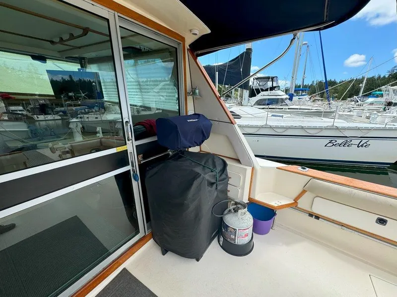 Slide: The Image of 1985 Sea Ray 390 Sedan Bridge deck with grill and marina view. - 7