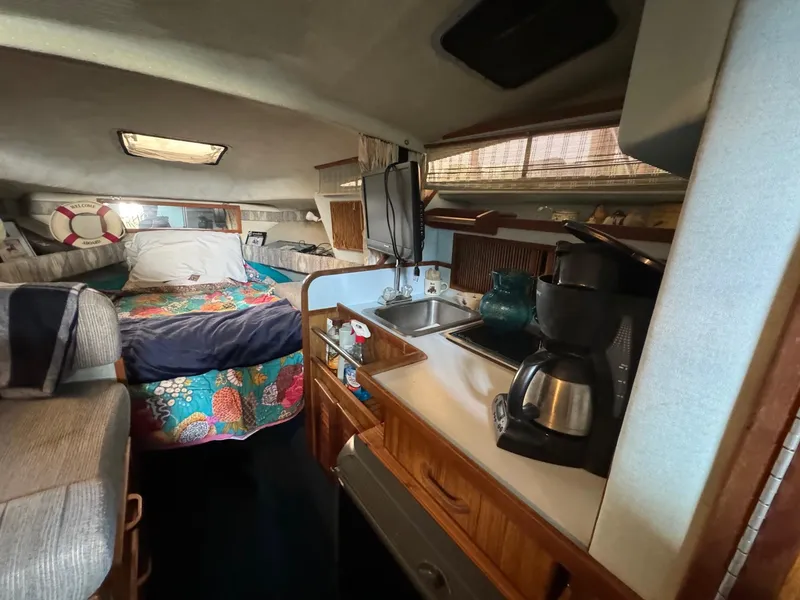 Slide: The Image of Interior of 1988 Sea Ray Sundancer 268 with kitchenette and cozy sleeping area. - 10